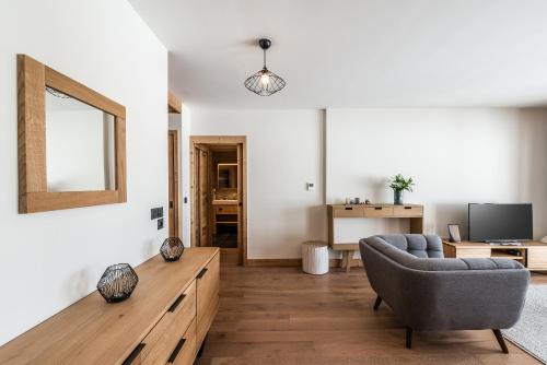 a living room with a couch and a television at Residence Hameau de Clotaire Alpe d'Huez - by EMERALD STAY in L'Alpe-d'Huez