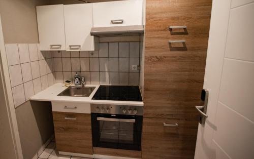a small kitchen with a sink and a stove at main Appartments Frankfurt Airport in Kelsterbach