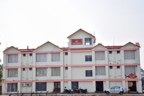 a building with a car parked in front of it at Dip Holidays in Shānti Niketan