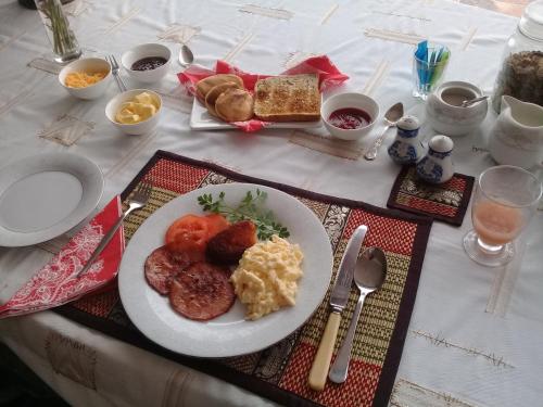 een tafel met een bord met ontbijt erop bij Traveller's Rest, Reebok in Mosselbaai