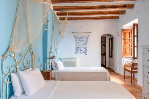 - une chambre avec 2 lits et un mur bleu dans l'établissement Son Borguny, à Banyalbufar
