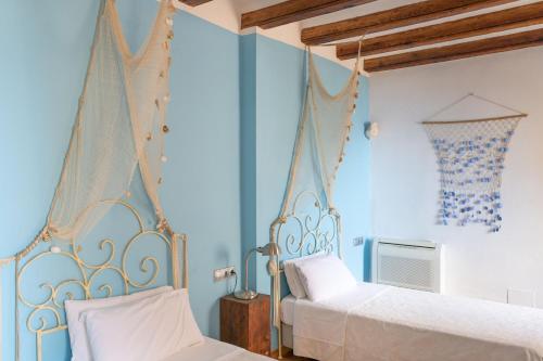 a bedroom with two beds and blue walls at Son Borguny in Banyalbufar