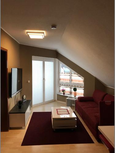 a living room with a red couch and a large window at FeWo-Wieseck in Gießen