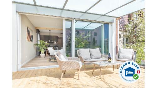 a glass extension of a house with chairs and a table at Eiche in Interlaken