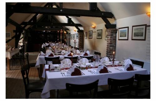 a dining room with tables and chairs with white table cloth at McMüller's Brauereigasthof in Kofferen