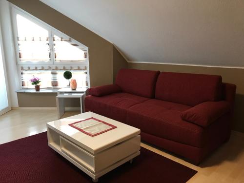 a living room with a red couch and a table at FeWo-Wieseck in Gießen