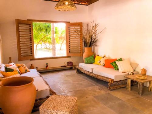 a living room with two couches and a window at Casa do CAMPO Atins com super Conforto in Atins