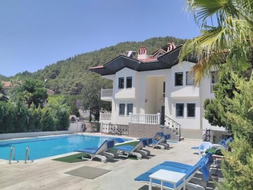 a villa with a swimming pool and a house at Peaceful Villa with Shared Pool Surrounded by Calming Nature in Marmaris in Muğla