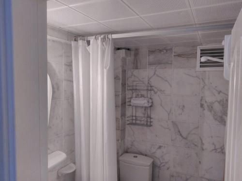 a bathroom with a white shower curtain and a toilet at Peaceful Villa with Shared Pool Surrounded by Calming Nature in Marmaris in Muğla