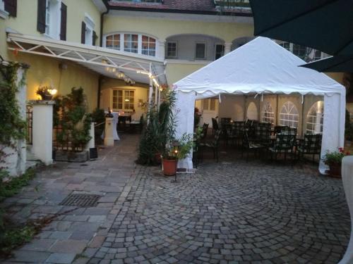 a patio with a white tent and tables and chairs at Rathausstüberl in Bad Radkersburg