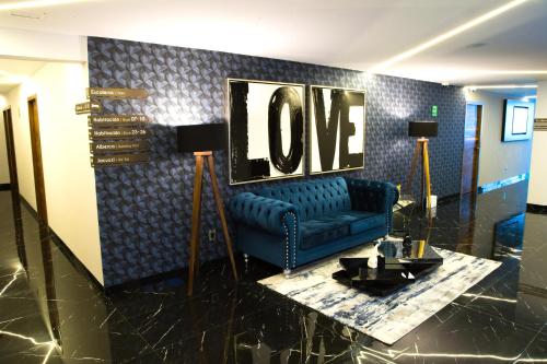 a living room with a blue couch and a love sign at Ramë Hotel Boutique in Guadalajara