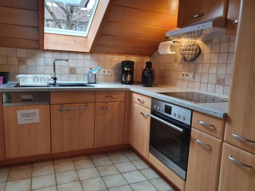 una cucina con mobili in legno, un lavello e una stufa di Schweizer´s Ferienwohnung ad Achberg