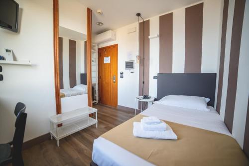 a bedroom with a bed with towels on a table at Hotel Continental in Reggio Calabria
