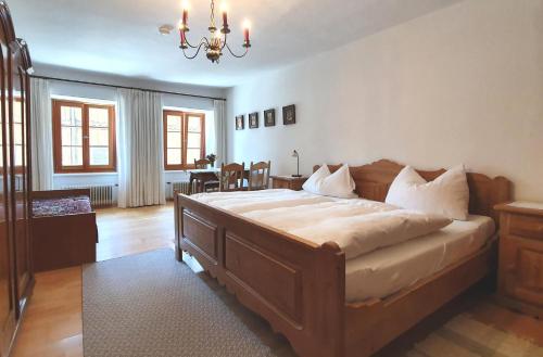 a bedroom with a large bed with a chandelier at Gästehaus Högerhof in Hopfgarten im Brixental