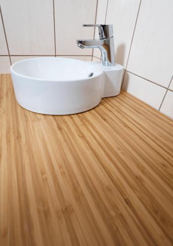 a white sink in a bathroom with a wooden floor at Apartman Patris 8 in Tatranska Strba