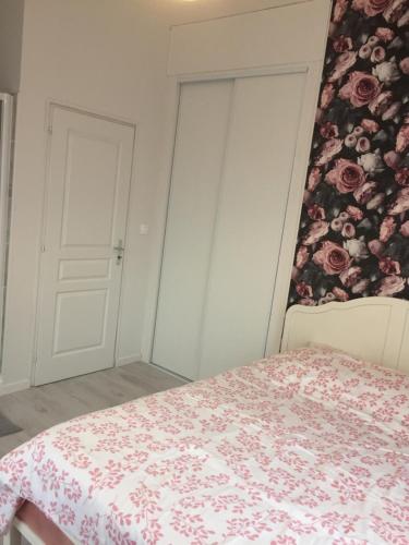 um quarto com uma cama com uma parede floral em La Vie est Belle em Abbeville