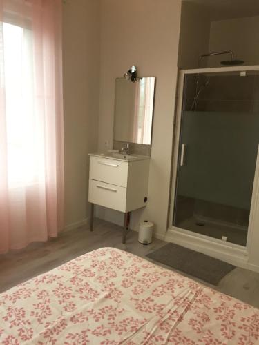 a bedroom with a bed and a sink and a mirror at La Vie est Belle in Abbeville