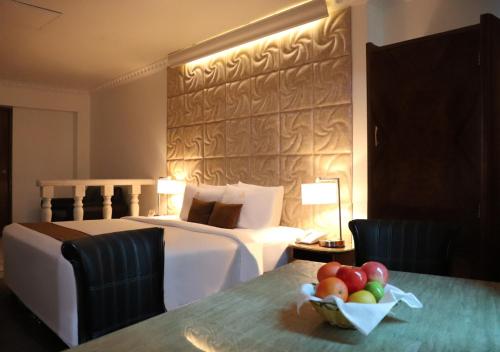 a hotel room with a bed and a bowl of fruit on a table at Suites Inkari in Lima