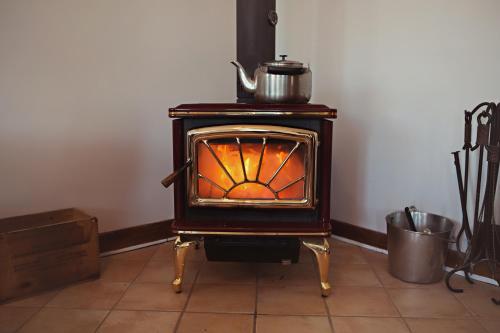 a stove with a tea kettle on top of it at Auberge Carpe Diem in Baie-Saint-Paul