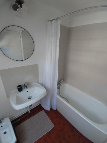 a bathroom with a sink and a tub and a mirror at Best of Chartres one bedroom city center and view on the Cathedral in Chartres