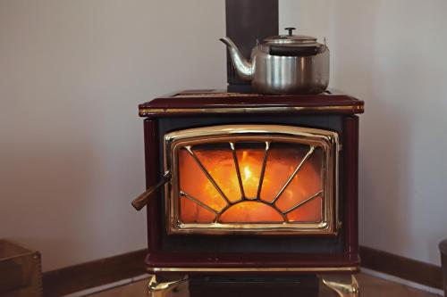 a wood stove with a pot on top of it at Auberge Carpe Diem in Baie-Saint-Paul
