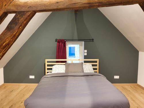 a bedroom with a bed in a attic at La graineterie89 in Pont-sur-Yonne