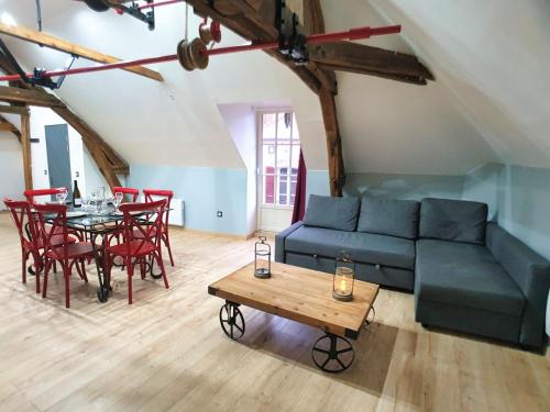 un salon avec un canapé, une table et des chaises dans l'établissement La graineterie89, à Pont-sur-Yonne