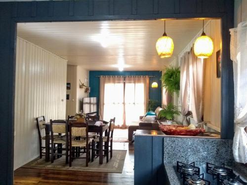 eine Küche und ein Wohnzimmer mit Tisch und Stühlen in der Unterkunft Happy House - Casa ideal para grupos na cidade dos Canyons in Praia Grande