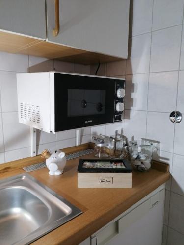 encimera de cocina con microondas y fregadero en Hotel Pension garni Haus am Strand en Norddeich
