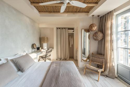 a bedroom with a large bed with a ceiling fan at Verina Astra in Artemonas