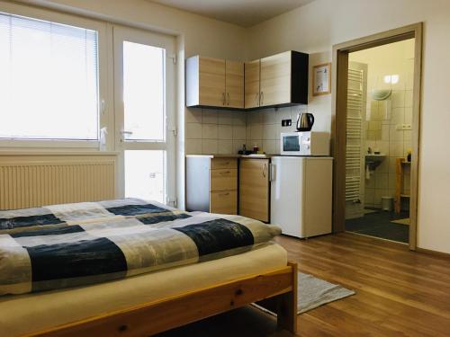 1 dormitorio con 1 cama y cocina con nevera en Ubytování u Malinků, en Přítluky