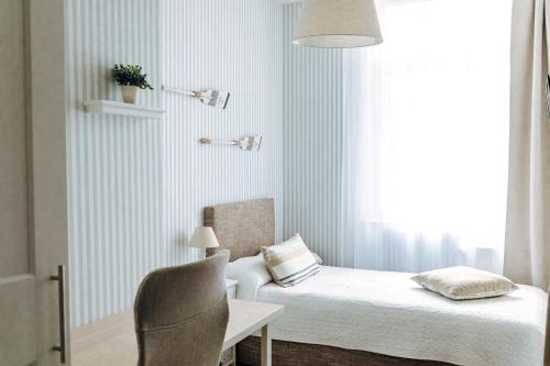 een slaapkamer met een bed, een stoel en een raam bij Apartment an der Altstadt (#8) in Hameln