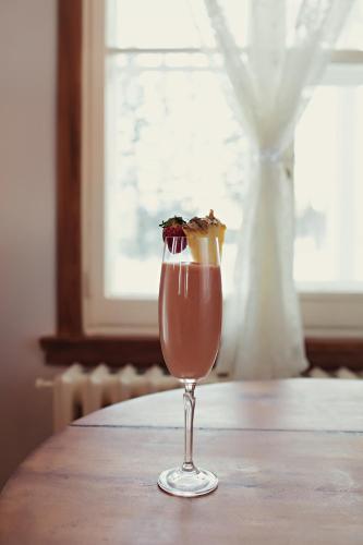 a drink in a glass sitting on a table at Auberge Carpe Diem in Baie-Saint-Paul