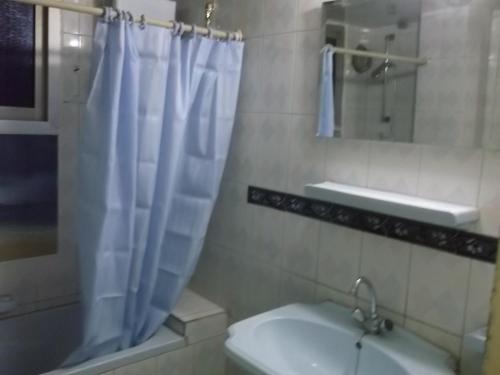 a bathroom with a white shower curtain and a sink at One-Bedroom Apartment at El Maali Street in Cairo