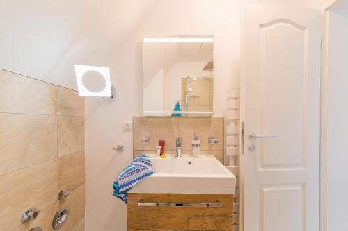 La salle de bains est pourvue d'un lavabo et d'un miroir. dans l'établissement Haus am Strand Ferienwohnung Haus am Strand 2, à Zingst
