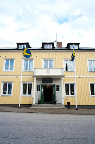 a yellow building with two flags in front of it at Reftele Wardshus in Reftele