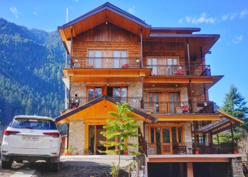 a house with a car parked in front of it at The Hillside in Kasol