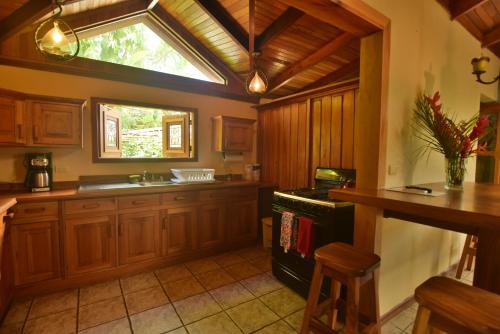 a large kitchen with wooden cabinets and a window at Mirador House, Cozy Private Home W- Volcano View in El Castillo de la Fortuna