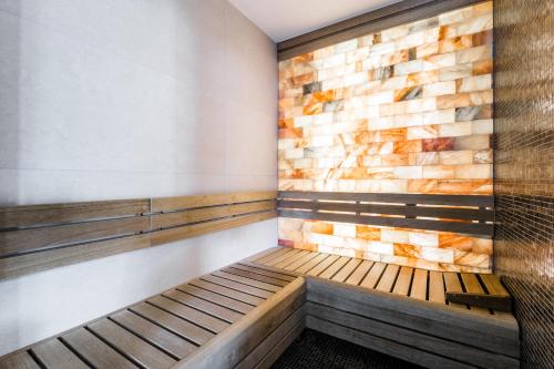 a room with a wooden bench and a brick wall at Globall Hotel in Telki