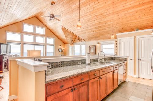 a kitchen with wooden ceilings and a large counter top at Looking Glass Inn in Depoe Bay