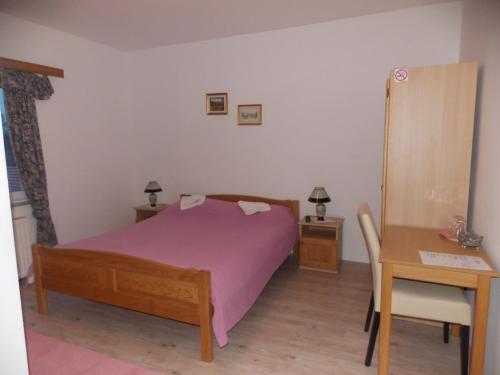 Našice的住宿－restoran i prenoćište Egghus，一间卧室配有一张床、一张桌子和一张书桌