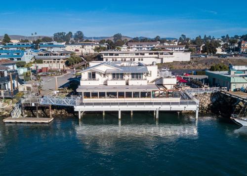 an aerial view of a large white building on the water at Inn At Rose's Landing in Morro Bay
