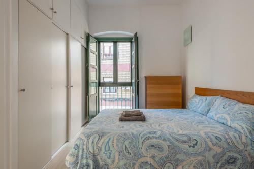 een slaapkamer met een bed en een raam bij Triana Flat, 3mn from plaza de Cuba in Sevilla