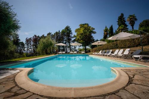 a swimming pool with chairs and umbrellas at Castel di Pugna in Siena