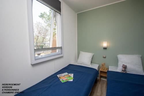 オプスにあるCamping International d'Aupsのベッドルーム1室(ベッド2台、窓付)
