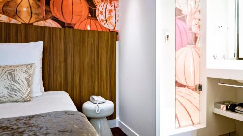 a bedroom with a bed and a wooden headboard at Mercure Lyon Centre Plaza République in Lyon