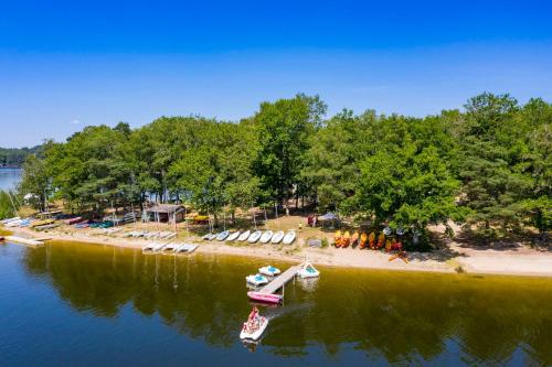 two boats in the water next to a beach at Camping du Lac in Marcillac-la-Croisille