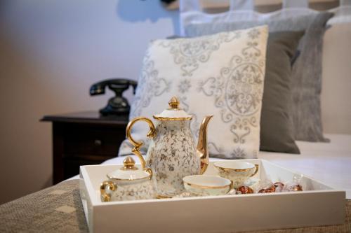 a tray with a tea kettle and cups on a bed at Agriturismo Tenuta Lagala in Venosa