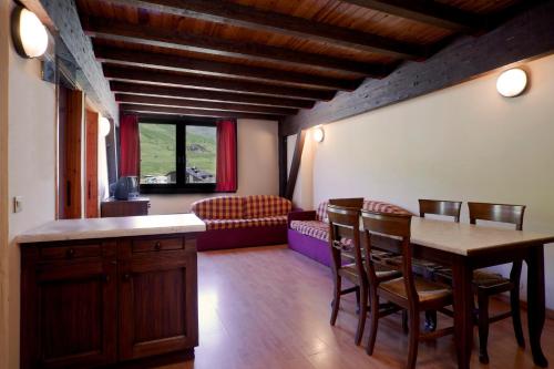 a living room with a table and chairs and a couch at Residence Savoia in Passo del Tonale