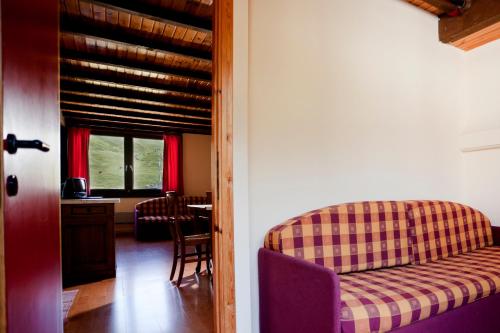 une chambre avec un canapé, une table et une fenêtre dans l'établissement Residence Savoia, à Passo del Tonale